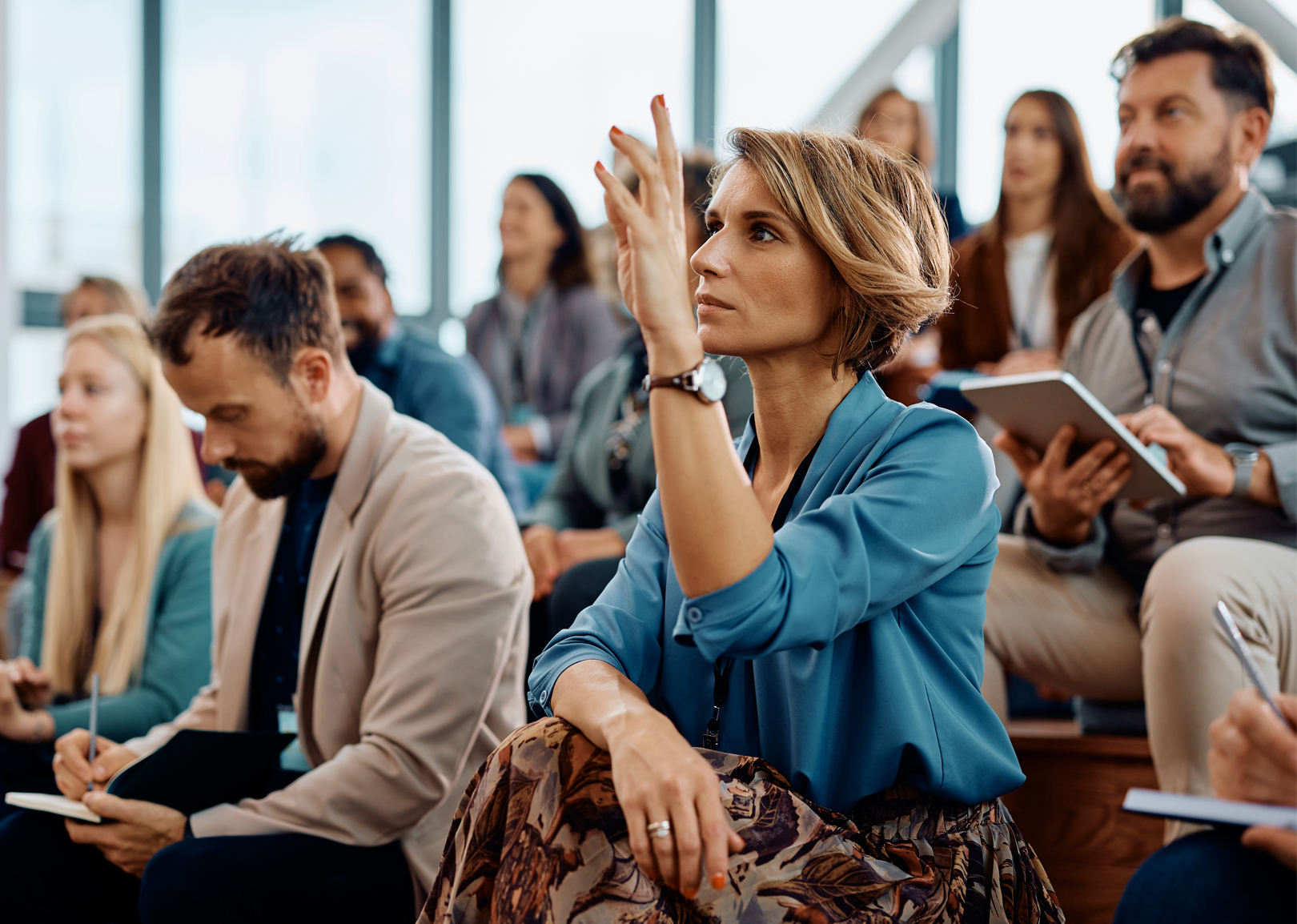 A female entrepreneur in an audience raising her h