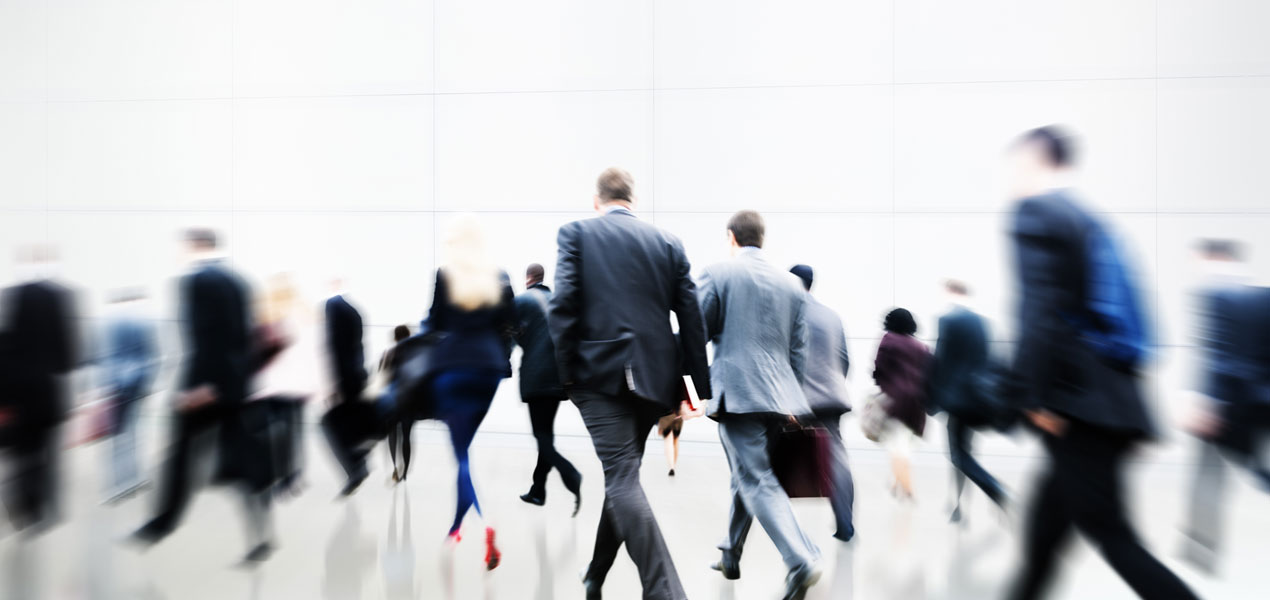 A crowd of business people walking in a hurry.