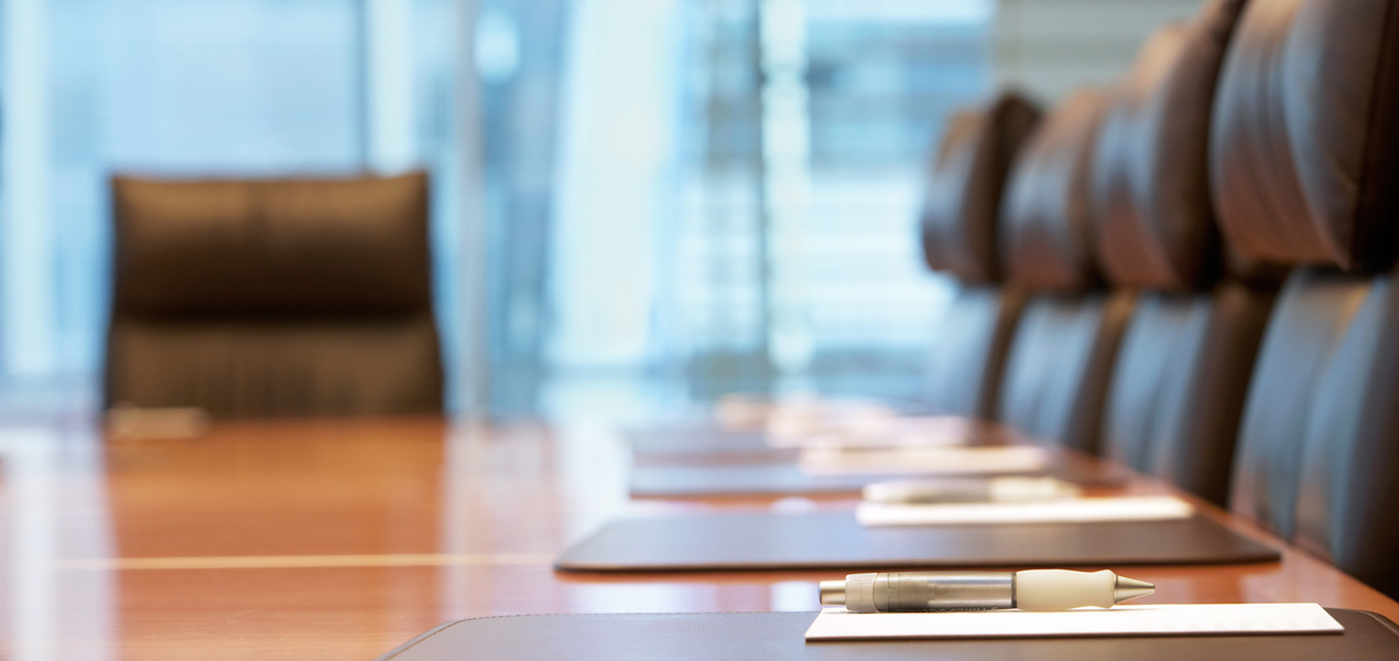 Close up of stationary set up on a meeting table in an empty boardroom.