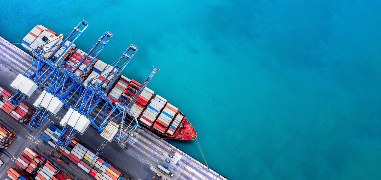 Bird's-eye view of a container ship on the water, emphasizing its cargo and the expansive marine environment.